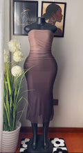 A strapless ruched midi dress in a muted taupe-brown color, displayed on a black mannequin. The dress features a gathered waist and a sheer overlay at the hem.