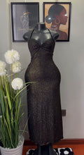 A sleeveless black halter-neck dress with a textured, glittery shimmer, displayed on a black mannequin. The dress features a sweetheart neckline with a twisted bow detail at the bust and a fitted silhouette.